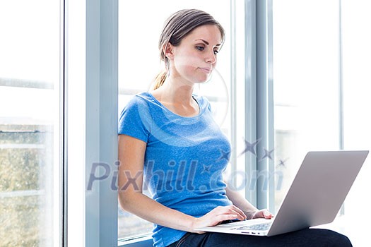 In the library - pretty female student with laptop and books working in a high school library (color toned image) In the library - pretty female student with laptop and books working in a high school library (color toned image)