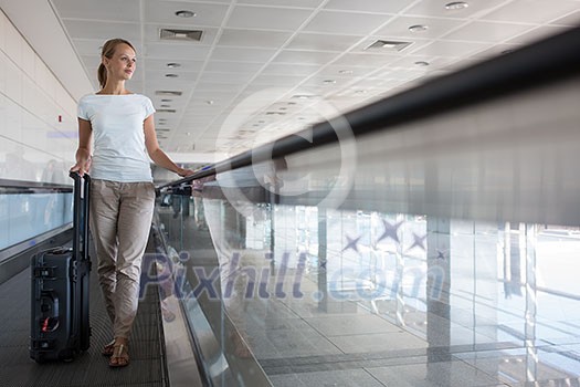Young female passenger at the airport, about to check-in, going to her departure gate (color toned image; shallow DOF) Young female passenger at the airport, about to check-in, going to her departure gate (color toned image; shallow DOF)