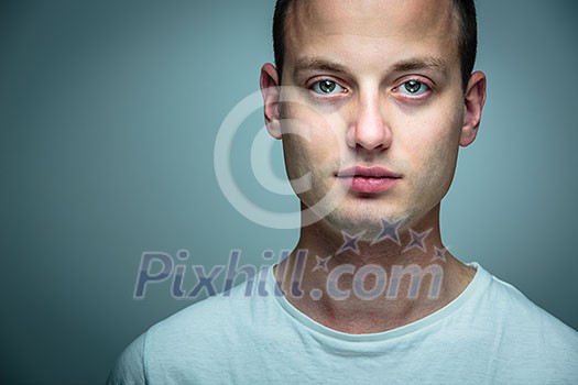 Portrait of a handsome young man, perfectly calm, facing the camera with emotionless expression Portrait of a handsome young man, perfectly calm, facing the camera with emotionless expression