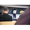 Senior male teacher teaching mathematics, writing on the blackboard