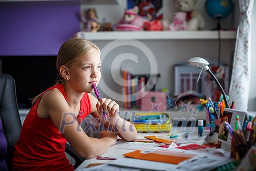 Portrait of cute schoolgirl dping her homework in her lovely room Portrait of cute schoolgirl dping her homework in her lovely room