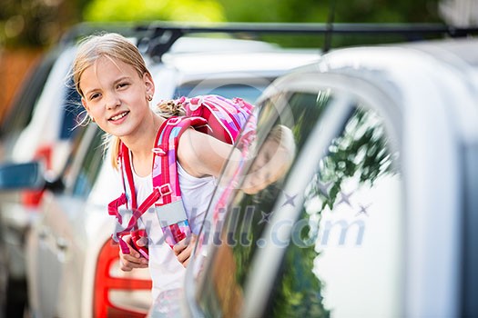Cute little girl going home from school, looking well before crossing the street Cute little girl going home from school, looking well before crossing the street