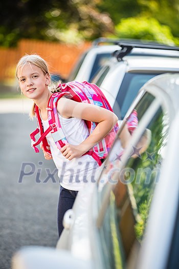 Cute little girl going home from school, looking well before crossing the street Cute little girl going home from school, looking well before crossing the street