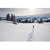 Pretty, young woman snowshoeing in high mountains, enjoying splendid winter weather with abundance of snow