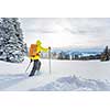 Young man snowshoeing in high mountains, enjoying splendid winter weather with abundance of snow