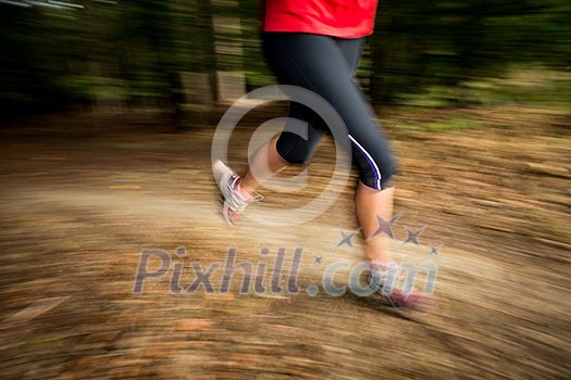 Young woman running outdoors in a forest, going fast (motion blurred image) Young woman running outdoors in a forest, going fast (motion blurred image)
