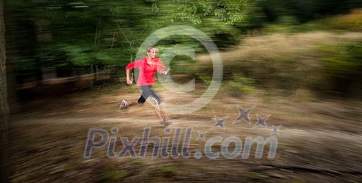 Young woman running outdoors in a forest, going fast (motion blurred image) Young woman running outdoors in a forest, going fast (motion blurred image)