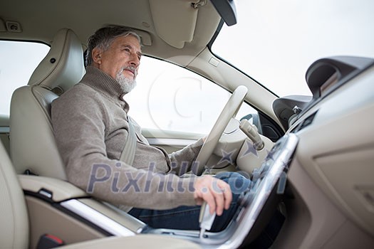 Senior drive driving his modern car, going in reverse, watching out not to hit anything or anyone (color toned image; shallow DOF) Senior drive driving his modern car, going in reverse, watching out not to hit anything or anyone (color toned image; shallow DOF)
