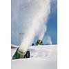 Snow-machine bursting artificial snow  over a skiing slope to alow for the skiing season to start