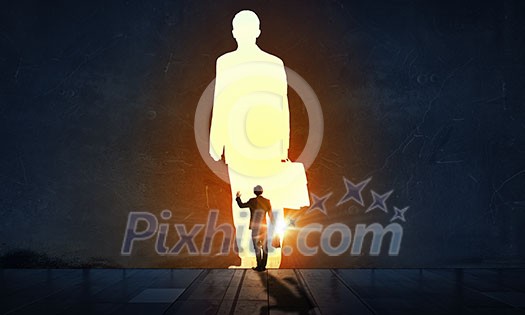 Back view of businessman standing in light representing success concept Back view of businessman standing in light representing success concept