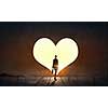 Businesswoman standing with back in light of heart door