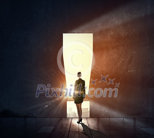 Businesswoman against black wall with exclamation mark hole Businesswoman against black wall with exclamation mark hole