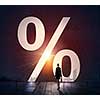 Businesswoman with suitcase in light of percentage door way