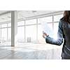Elegant businesswoman in modern office interior against window panoramic view