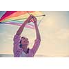 Beautiful Young Woman having fun with a kite at Beach on autumn day