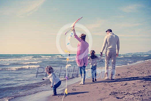 young family with kids resting and having fun with a kite at beach during autumn day young family with kids resting and having fun with a kite at beach during autumn day