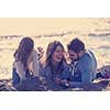 Family with kids resting and having fun at beach during autumn day