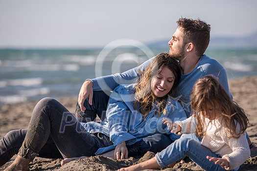 Family with kids resting and having fun at beach during autumn day Family with kids resting and having fun at beach during autumn day
