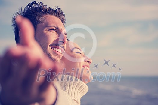Young couple having fun walking and hugging on beach during autumn sunny day Young couple having fun walking and hugging on beach during autumn sunny day