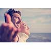 Young couple having fun walking and hugging on beach during autumn sunny day