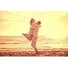 Young couple having fun walking and hugging on beach during autumn sunny day filter