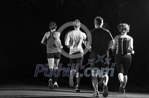 group of healthy people jogging in city park, runners team at night training group of healthy people jogging in city park, runners team at night training