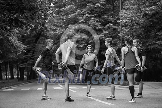 healthy runners team warming up and stretching in city park before morning training healthy runners team warming up and stretching in city park before morning training