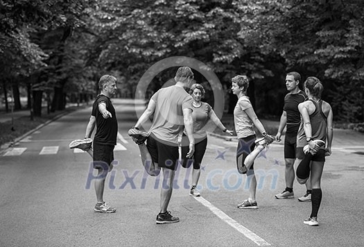 healthy runners team warming up and stretching in city park before morning training healthy runners team warming up and stretching in city park before morning training