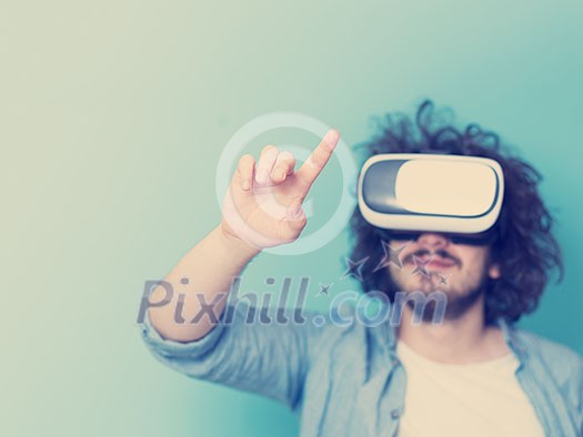 Happy man getting experience using VR headset glasses of virtual reality, isolated on blue background