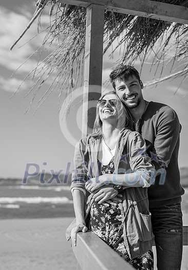 Happy couple enyojing time together on beach during autumn day Happy couple enyojing time together on beach during autumn day