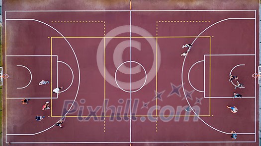 Aerial view strictly from above with the drone to a basketball court with players and ball. Sports game in basketball. Top view. Aerial view strictly from above with the drone to a basketball court with players and ball. Sports game in basketball. Top view.