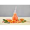 Vegetarian colorful orange cocktail from organic vegetables, fruits and berries on a paper background with copy space. Concept of natural organic healthy food.
