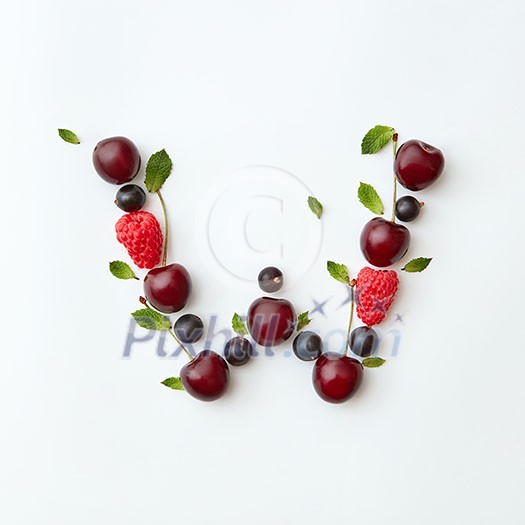 Letter W english alphabet in the form of a pattern of natural organic berries - ripe fresh raspberry, black currant, cherry, green mint leaf isolated on a white background. Top view. Letter W english alphabet in the form of a pattern of natural organic berries - ripe fresh raspberry, black currant, cherry, green mint leaf isolated on a white background. Top view.