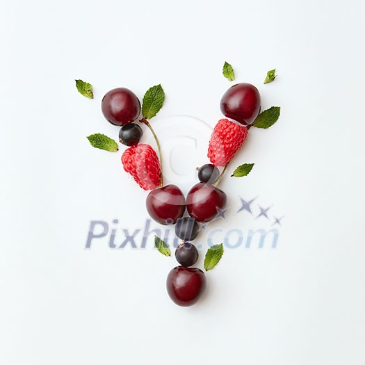 Letter Y english alphabet in the form of a pattern of natural organic berries - ripe fresh raspberry, black currant, cherry, green mint leaf isolated on a white background. Top view. Letter Y english alphabet in the form of a pattern of natural organic berries - ripe fresh raspberry, black currant, cherry, green mint leaf isolated on a white background. Top view.