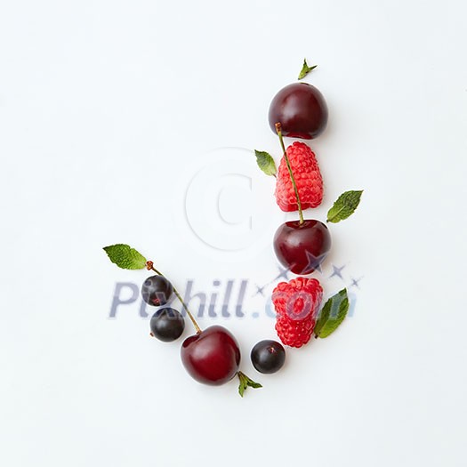 Letter J english alphabet in the form of a pattern of natural organic berries - ripe fresh raspberry, black currant, cherry, green mint leaf isolated on a white background. Top view. Letter J english alphabet in the form of a pattern of natural organic berries - ripe fresh raspberry, black currant, cherry, green mint leaf isolated on a white background. Top view.