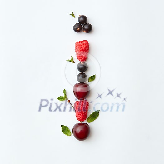 Letter I english alphabet in the form of a pattern of natural organic berries - ripe fresh raspberry, black currant, cherry, green mint leaf isolated on a white background. Top view. Letter I english alphabet in the form of a pattern of natural organic berries - ripe fresh raspberry, black currant, cherry, green mint leaf isolated on a white background. Top view.