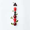 Letter I english alphabet in the form of a pattern of natural organic berries - ripe fresh raspberry, black currant, cherry, green mint leaf isolated on a white background. Top view.