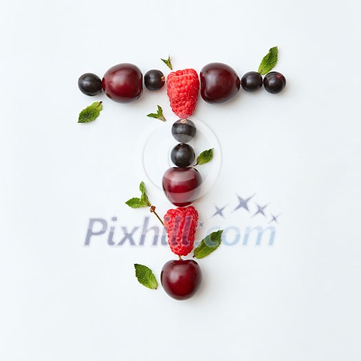 Letter T english alphabet in the form of a pattern of natural organic berries - ripe fresh raspberry, black currant, cherry, green mint leaf isolated on a white background. Top view. Letter T english alphabet in the form of a pattern of natural organic berries - ripe fresh raspberry, black currant, cherry, green mint leaf isolated on a white background. Top view.