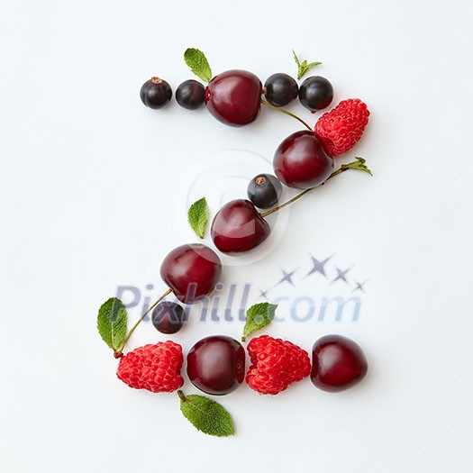 Letter Z english alphabet in the form of a pattern of natural organic berries - ripe fresh raspberry, black currant, cherry, green mint leaf isolated on a white background. Top view. Letter Z english alphabet in the form of a pattern of natural organic berries - ripe fresh raspberry, black currant, cherry, green mint leaf isolated on a white background. Top view.