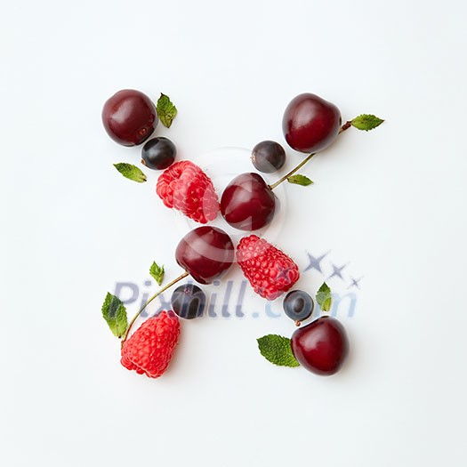 Letter X english alphabet in the form of a pattern of natural organic berries - ripe fresh raspberry, black currant, cherry, green mint leaf isolated on a white background. Top view. Letter X english alphabet in the form of a pattern of natural organic berries - ripe fresh raspberry, black currant, cherry, green mint leaf isolated on a white background. Top view.