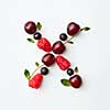Letter X english alphabet in the form of a pattern of natural organic berries - ripe fresh raspberry, black currant, cherry, green mint leaf isolated on a white background. Top view.
