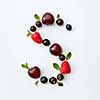 Letter S english alphabet in the form of a pattern of natural organic berries - ripe fresh raspberry, black currant, cherry, green mint leaf isolated on a white background. Top view.