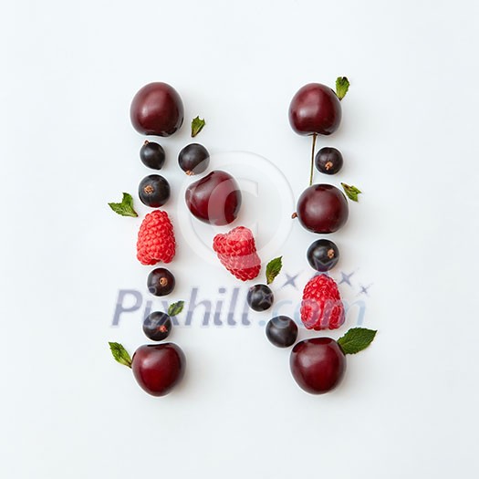 Letter N english alphabet in the form of a pattern of natural organic berries - ripe fresh raspberry, black currant, cherry, green mint leaf isolated on a white background. Flat lay Letter N english alphabet in the form of a pattern of natural organic berries - ripe fresh raspberry, black currant, cherry, green mint leaf isolated on a white background. Flat lay