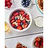 Healthy organic breakfast from natural ingredienrs - granola, strawberries, blueberries, milk, almonds, floral honey. Concept of natural healthy detox food. Top view.