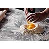 On a kitchen table a pile of flour with yolks, baker pours the squirrels into the flour. Step-by-step preparation of the dough