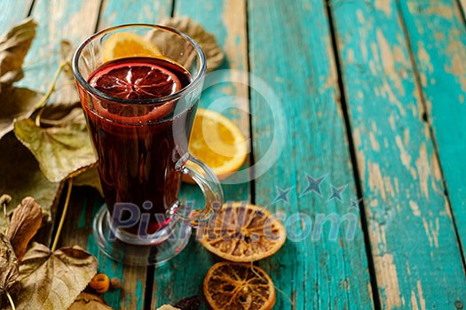 Hot mulled wine with orange, cinnamon, cardamom and anise on green wooden background. Hot mulled wine with orange, cinnamon, cardamom and anise on green wooden background.