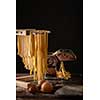 Freshly prepared Tagliatelle paste is dried on a wooden drier. Traditional italian cuisine.