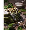 Pancakes with spinach and pumpkin seeds on a wooden table. Country style.