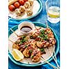 Chicken kebab on skewers with cherry, mushrooms and barbecue sauce on a blue background. 