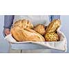 Bread assortment in the hands of the baker, horizontal banner, close-up.